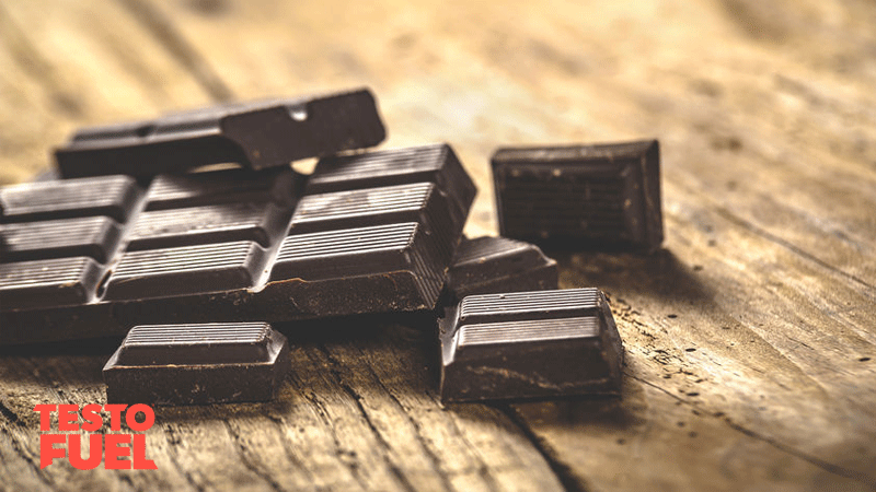 Squares of dark chocolate placed on a wooden table
