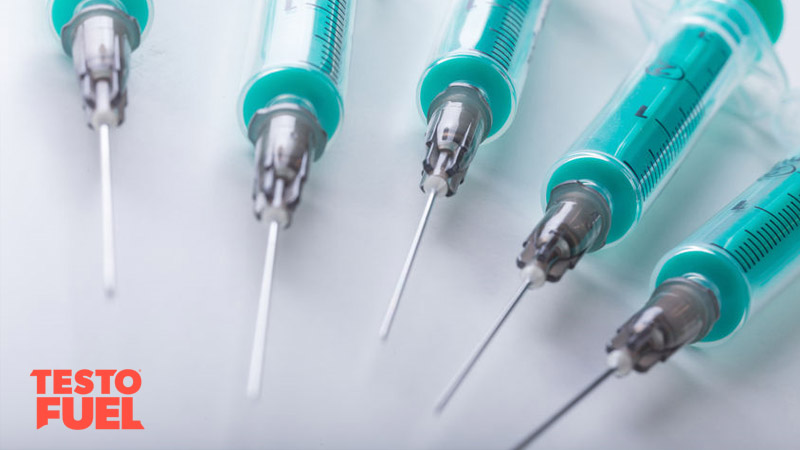 A range of needles / syringes laif out in a circle on a white background