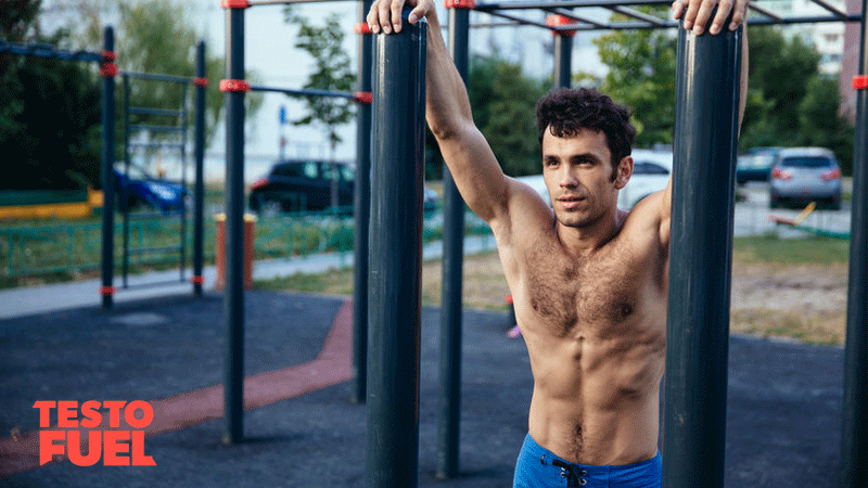Tanned and athletic man stood relaxing in an outdoor gym