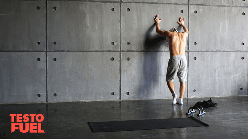 Crossfit athlete stood resting and tired in the gym