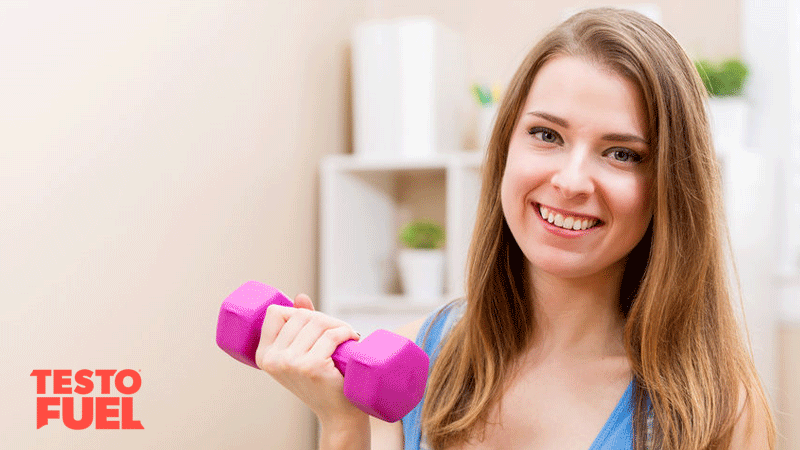 Young woman holding a dumbbell doing a workout at home