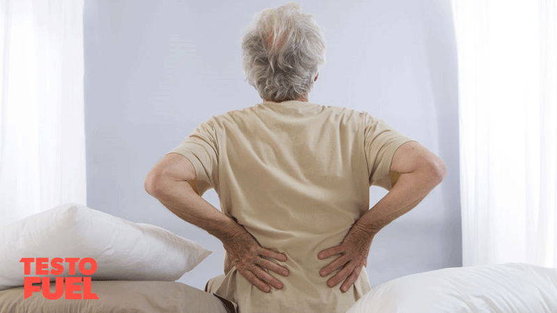 Older man suffering with back pain in bed