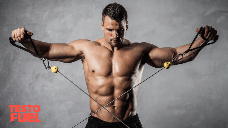 Athletic man pumping up muscles on crossover