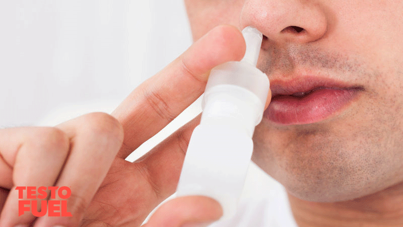 Man in white shirt using a nasal spray for testosterone