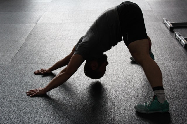  Man stretching to stay healthy at home